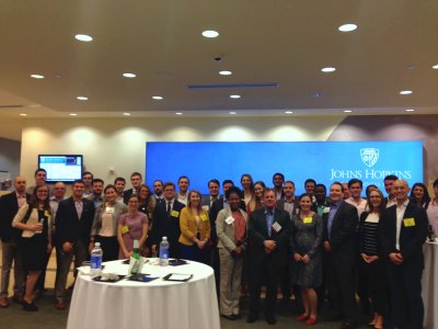Large group of attendees standing together in front of a Johns Hopkins banner at the joint event with ACG Maryland.