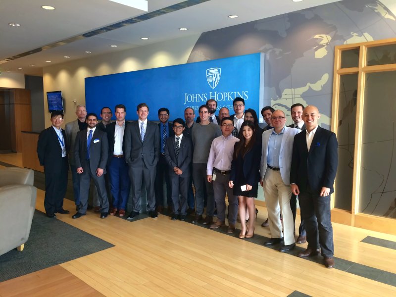 Group photograph of participants in front of a Johns Hopkins banner at the Venture Capital Investment Competition.